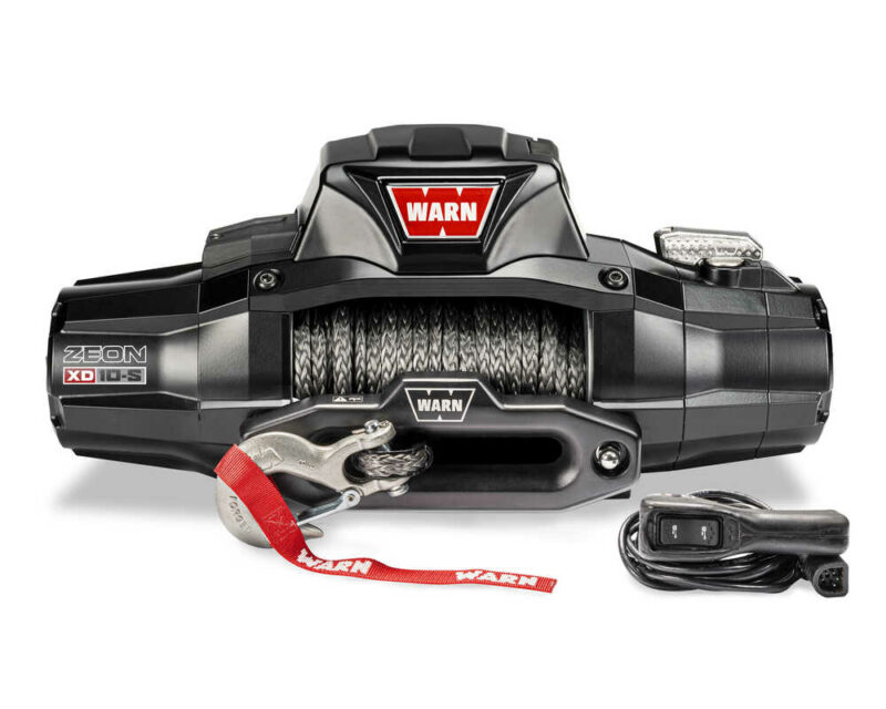 A Warn Zeon XD 10-S winch with synthetic rope, hook, and remote control, displaying the company logo prominently.