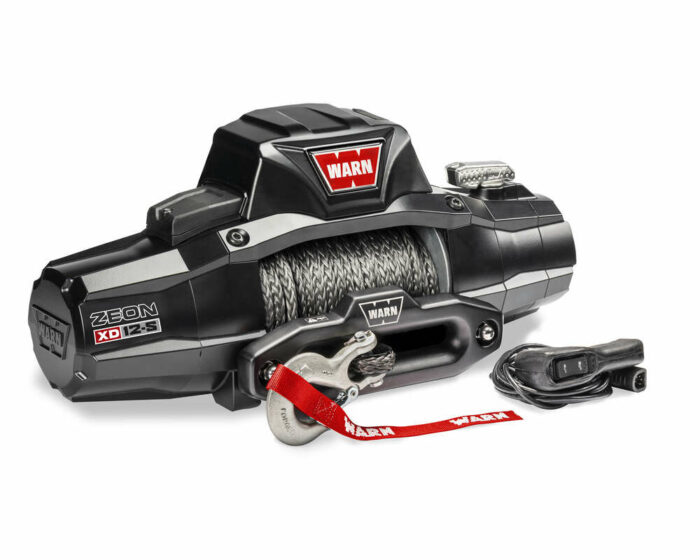 A WARN ZEON winch with a synthetic rope and red tag, featuring a sturdy design and attached remote control.