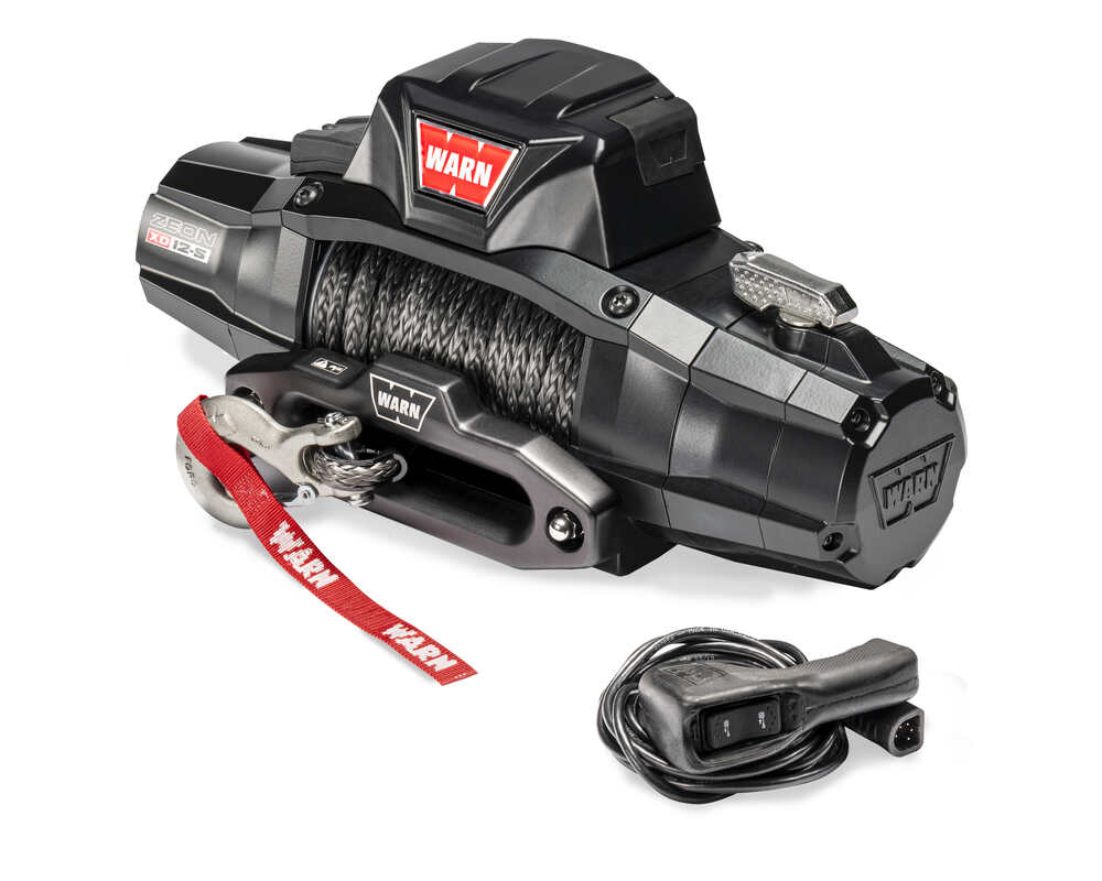 Black Warn winch with synthetic rope and a remote control, featuring red accents and branding.