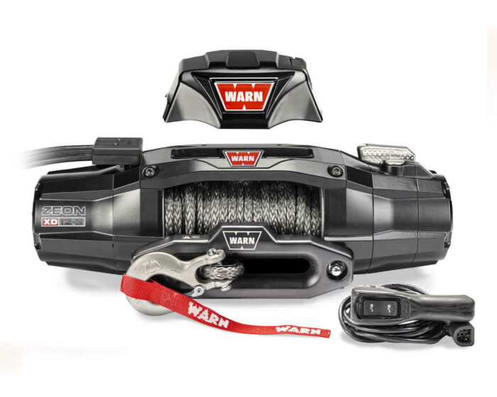 Heavy-duty Warn winch with cable, remote control, and branded cover, designed for off-road vehicle recovery.